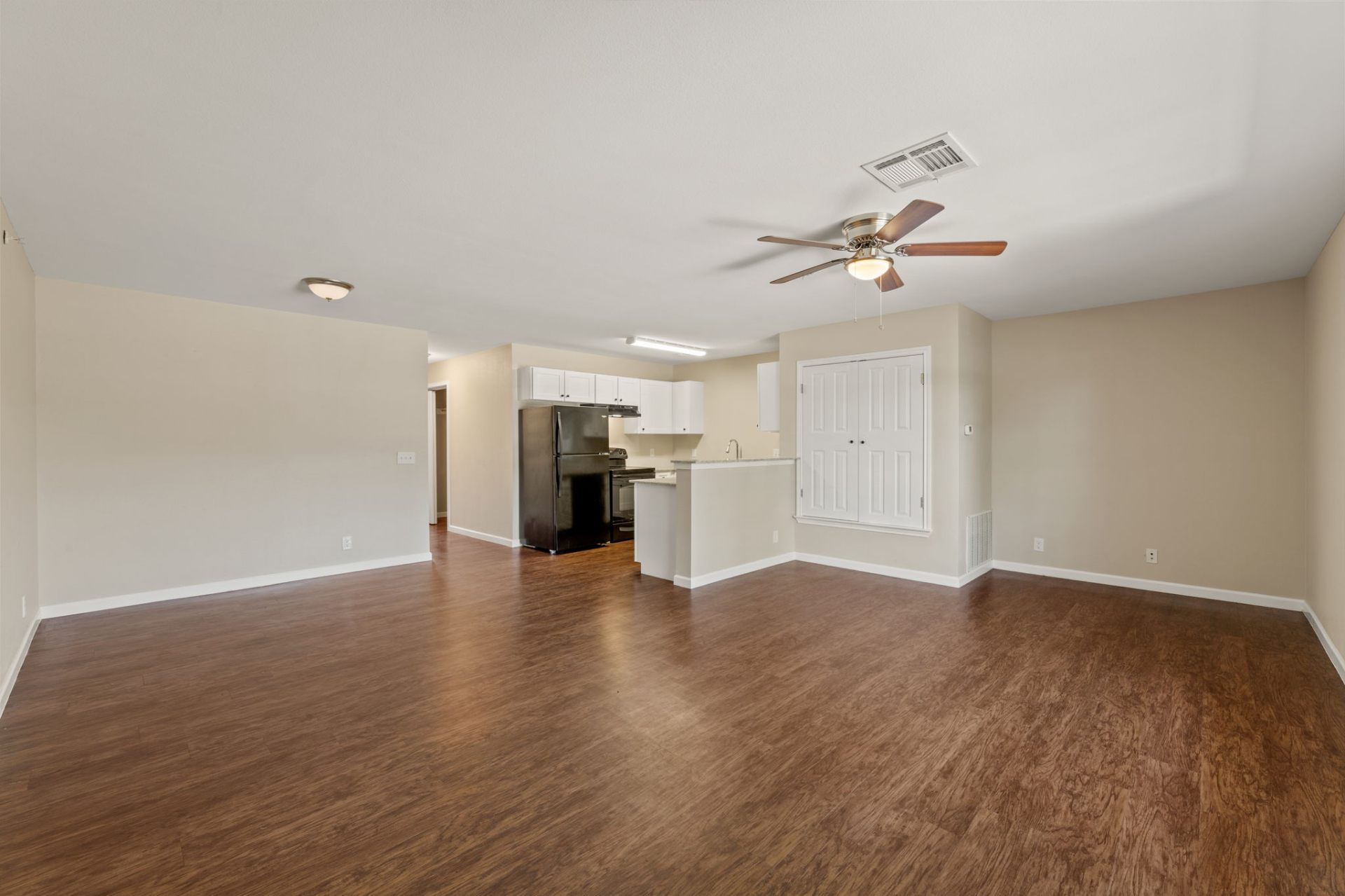 Open living and dining area with vinyl plank flooring and ceiling fan